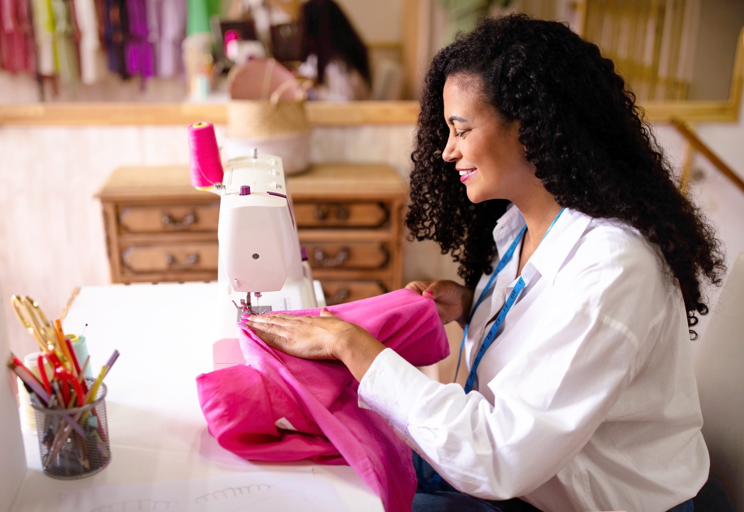 Side View Of Middle Eastern Tailor Lady Sewing Garment Indoor